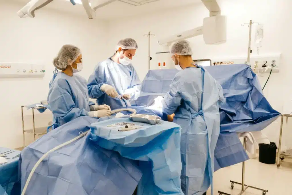Surgeons wearing disposable ppe while operating on a patient.