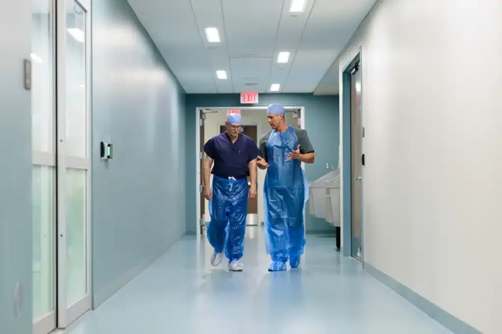 Two medical professionals in PPE discuss adding essential PPE for disaster relief workers on their team.
